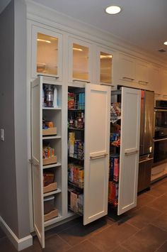 a kitchen with two white refrigerators in it's side by side cabinets and an oven