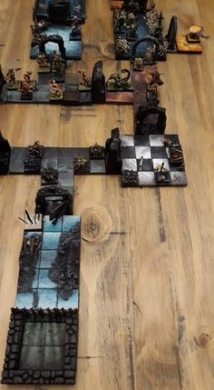 several pieces of art sitting on top of a wooden floor in the shape of chess boards