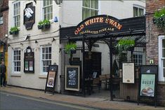 an old white swan restaurant on the corner of a street