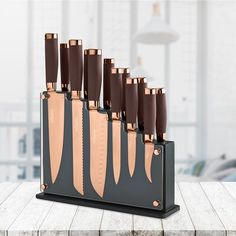 a set of knives sitting on top of a wooden table next to a knife holder