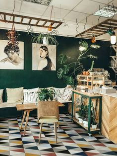 a room filled with lots of green plants and pictures on the wall next to a counter