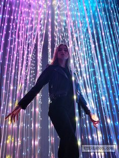 a woman standing in front of colorful lights