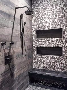 a walk in shower sitting next to a wooden wall