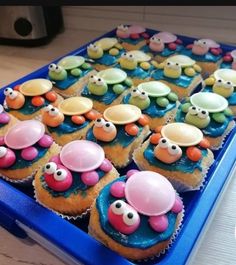 some cupcakes are decorated with googly eyes and other things in them on a blue tray