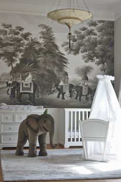 an elephant standing in the middle of a room next to a crib and dresser