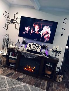 a living room filled with furniture and a flat screen tv mounted on the wall above a fireplace