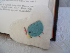 a close up of a bookmark with a blue bird on it's side