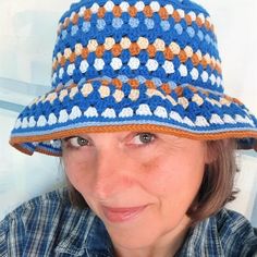 a woman wearing a crocheted blue and orange hat