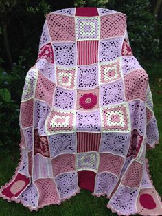 a crocheted blanket sitting in the grass