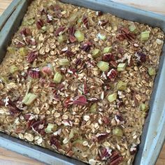 a pan filled with granola and nuts on top of a wooden table