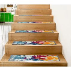 a set of wooden stairs with colorful rugs on the bottom and hand painted steps