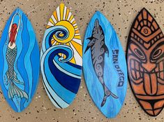 three surfboards painted with different designs on them