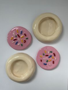 three pink and white plates with sprinkles on them