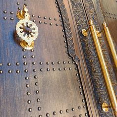 a close up of a metal door with rivets and a key on it