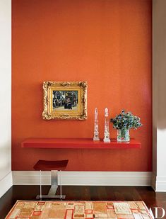 an orange room with a painting on the wall