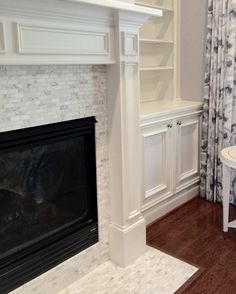 a living room with white furniture and a fireplace