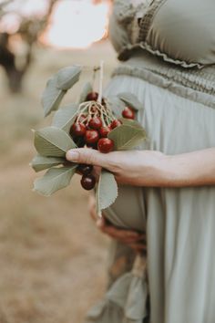 a pregnant woman holding berries in her hands