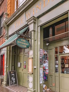 the building is green and has signs on it that say the winding hair salon