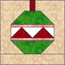 a green and red christmas ornament on a beige background with white trimmings