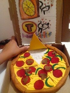 someone is holding up a pizza shaped like a face