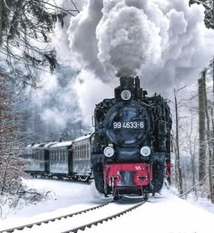 an old fashioned steam train traveling through the snow