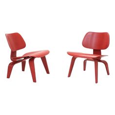 two red chairs sitting side by side on a white background