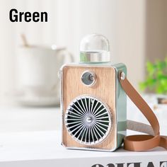 an old fashioned camera sitting on top of a white table next to a brown ribbon