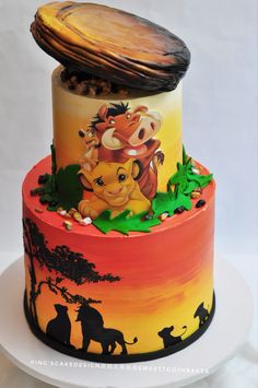 a multi layer cake decorated with an image of the lion king