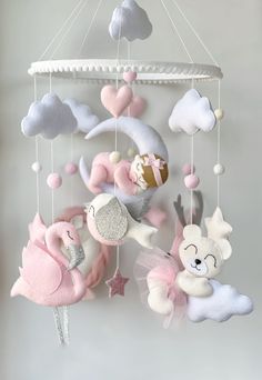 a pink and white baby mobile hanging from the ceiling with clouds, teddy bears and stars