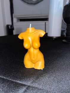 a yellow candle sitting on top of a table