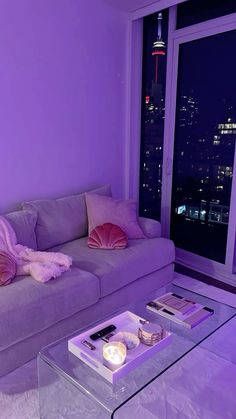 a living room filled with furniture and a purple couch next to a window at night