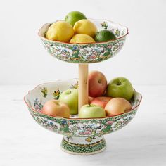 two tiered bowls filled with apples and lemons