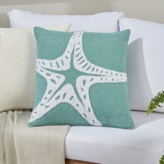 a starfish pillow sitting on top of a white couch