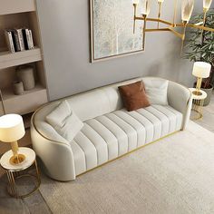 a living room with a white couch and two lamps on either side of the couch