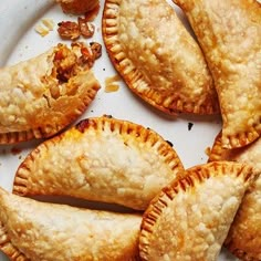 several pastries on a white plate with nuts