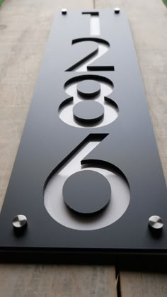 a sign that is on the side of a wooden building with metal letters and numbers