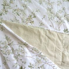 an unmade bed with green leaves on it