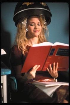 a woman wearing a hat and reading a book