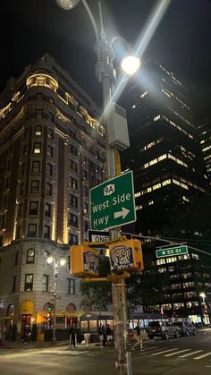 a street sign on the corner of west side and n wy streets at night