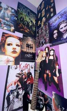 a guitar sitting in front of a wall covered with pictures and music memorabilia on it