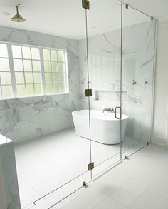 a white bathroom with marble walls and floor