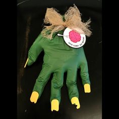 a green hand with yellow gloves and a pink heart on it's palm that says i love you