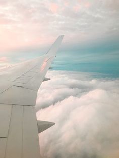 the wing of an airplane flying above clouds