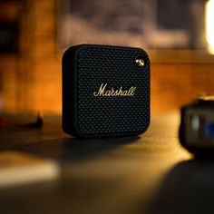 a black speaker sitting on top of a wooden table