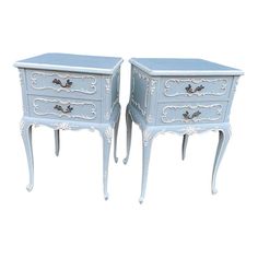 two blue nightstands with drawers on each side and one drawer open to show the same item