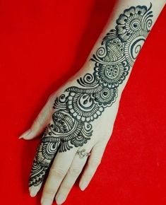 the hand is decorated with black henna