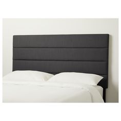 an upholstered headboard on a bed with white sheets