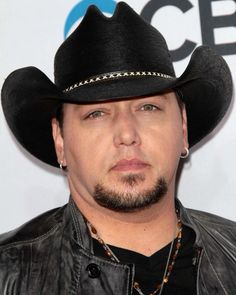 a man wearing a black cowboy hat and leather jacket on the red carpet at an awards event