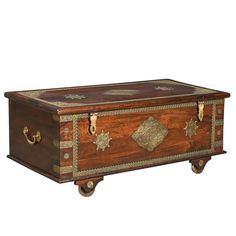 an old wooden trunk with gold decorations on the top and bottom, sitting against a white background