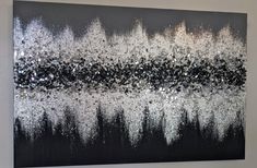 a black and white painting with silver glitters on it's edges, hanging on a wall